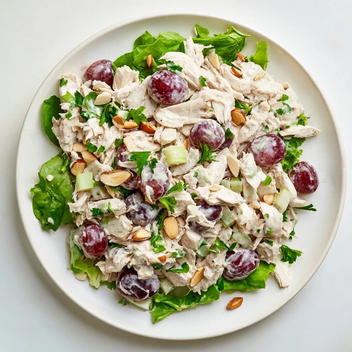 Creamy crispy chicken salad with grapes, served on a bed of fresh, vibrant salad greens.