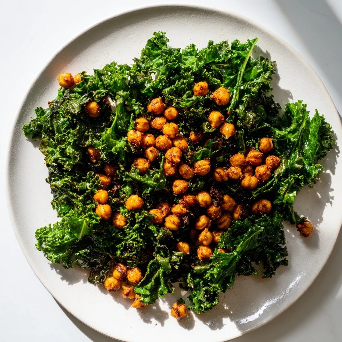 A bowl of flavorful Warm Kale Salad with crispy chickpeas, ready to enjoy as a meal.