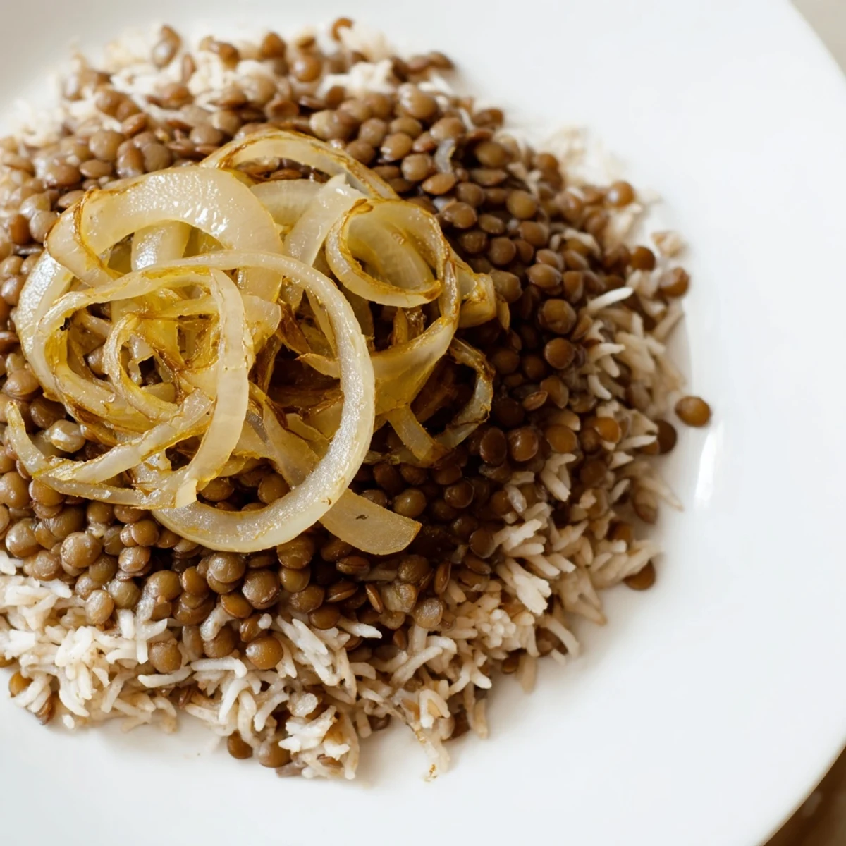 Golden, caramelized onions topping a warm bowl of Lebanese Mjadra, a hearty lentil and rice dish.