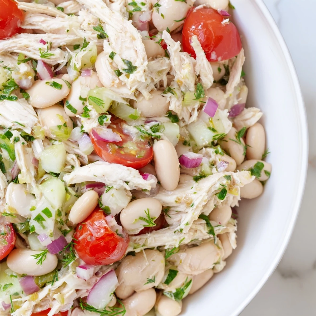 A vibrant bowl of Lemony White Bean Chicken Salad with tender chicken, creamy white beans, and crisp celery tossed in a zesty lemon vinaigrette.