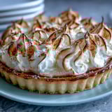 Freshly baked Lemon Meringue Pie showing a crisp pastry crust and fluffy, cloud-like meringue topping.  