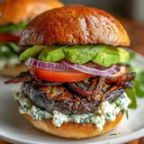 Hearty grilled portobello burgers with creamy avocado, perfect for a flavorful cookout.
