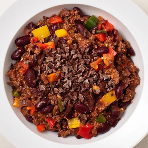 A close-up of a bowl of One-Pot Cozy Chocolate Chili, garnished with cilantro, ready to eat.