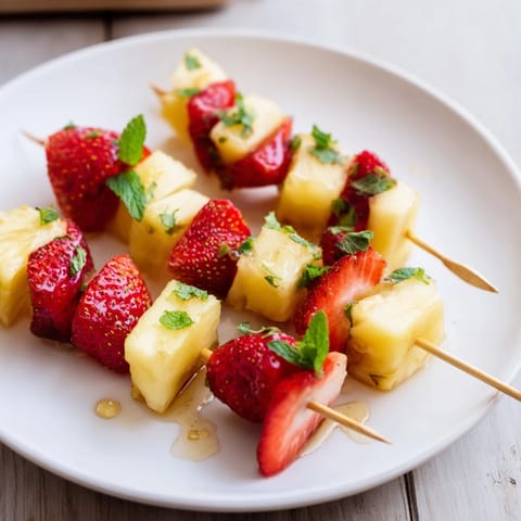Summery fruit skewers with pineapple and strawberries ready to serve, a perfect cookout treat.