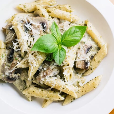 A hearty bowl of Mushroom Pesto Pasta tossed with penne and parmesan, served warm and comforting.